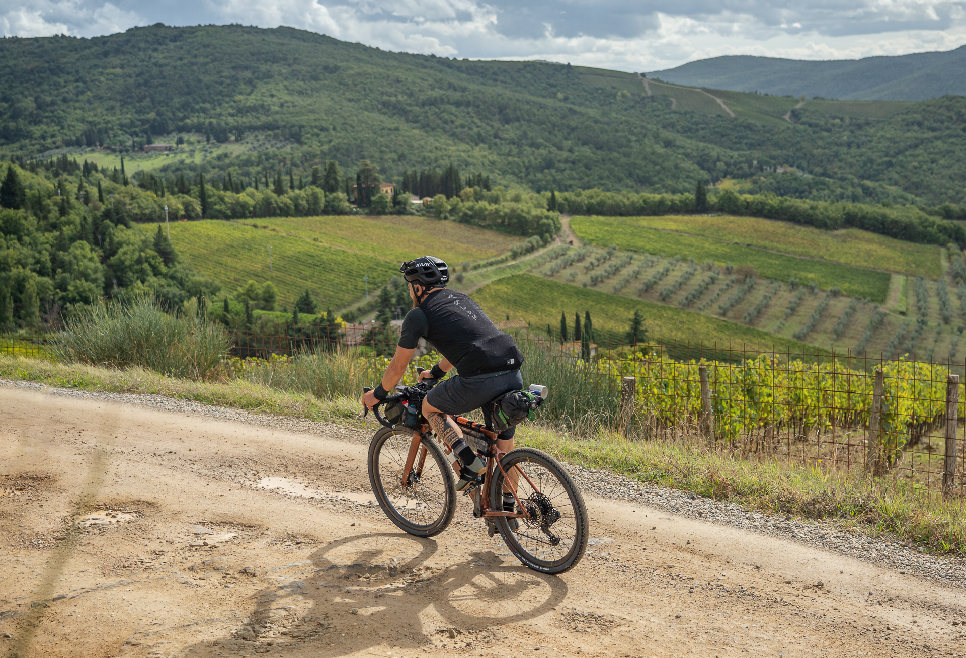 a cyclist on a gravel road between florence and siena